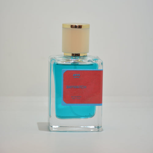 A rectangular glass perfume bottle with turquoise blue liquid, a red label, and a beige cap, shown against a plain light background. It is Baywatch.